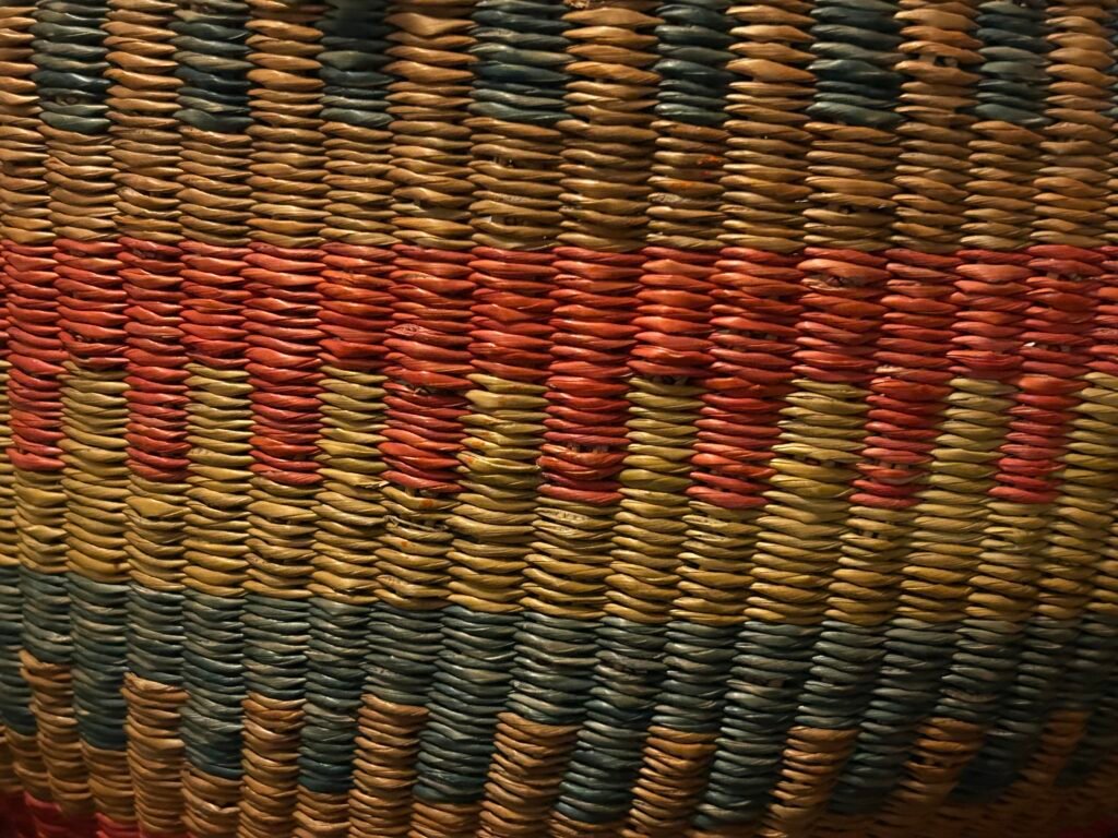 Close up of the woven fibres of a basket, in different colours